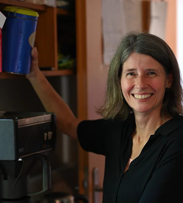 Tina Hinderlich Köchin lächelt in die Kamera und nimmt dabei etwas aus dem Schrank